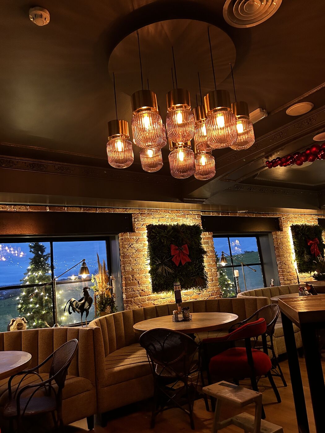 The Barn dressed for Christmas — wreaths, gold lights and a lit tree in the morning