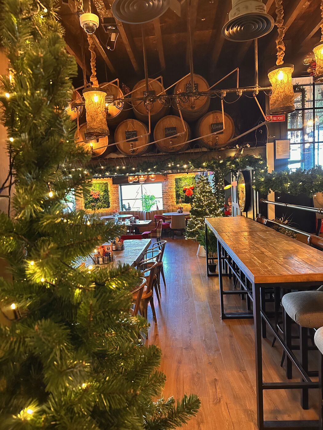 The Barn dining room with the barrels, garlands and a decorated Christmas tree