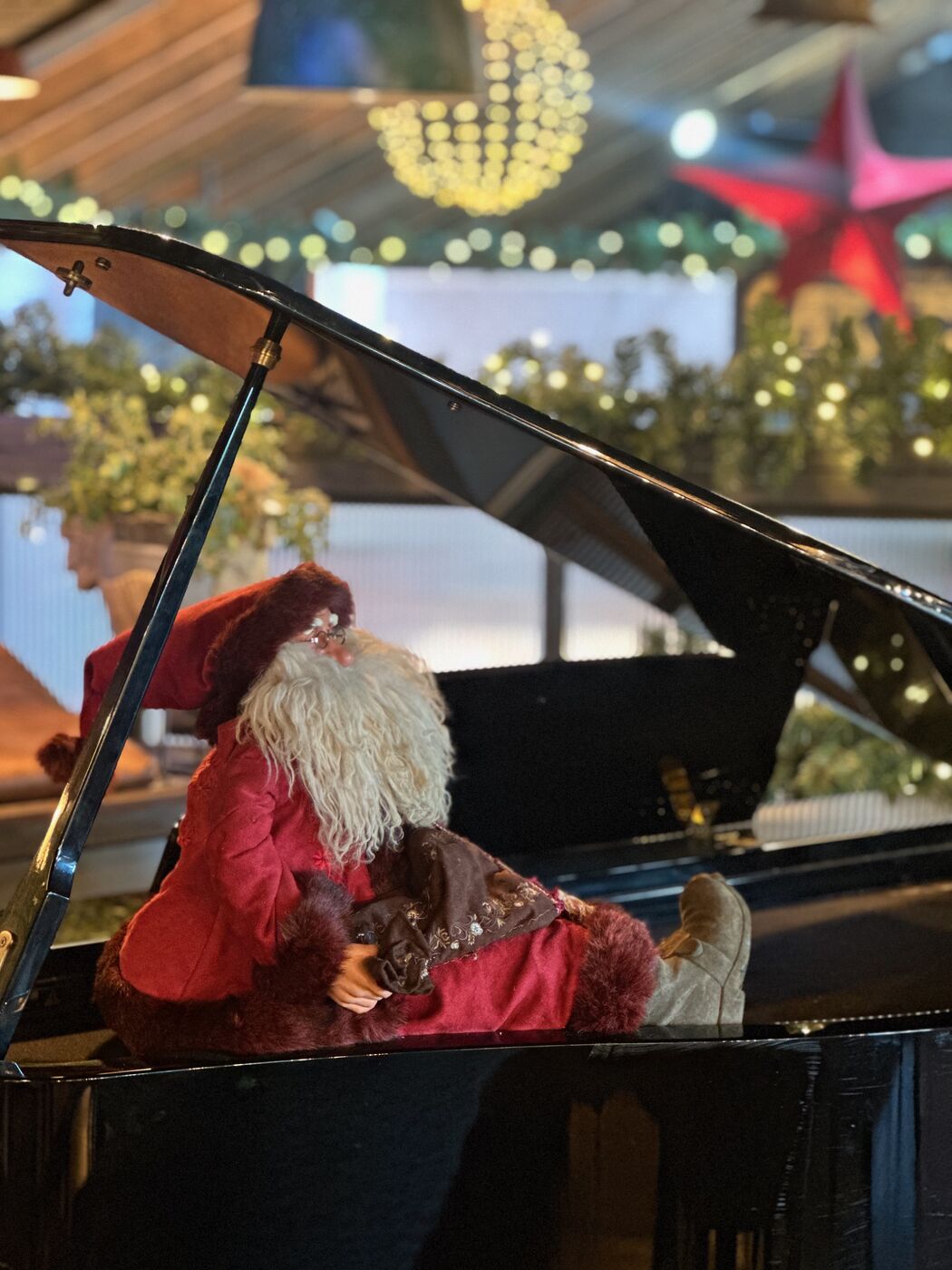 Santa at the piano at The Barn, surrounded by Christmas garlands
